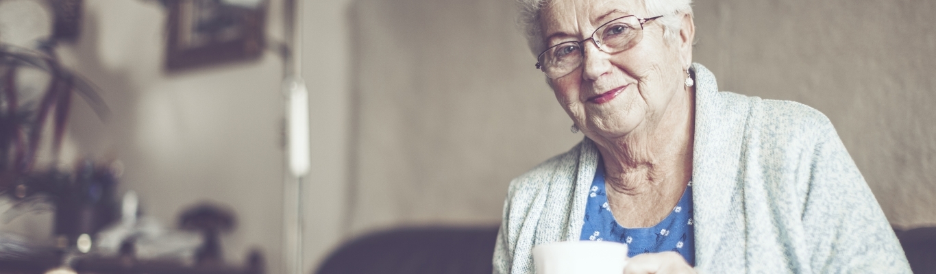 Senior woman on couch with coffee